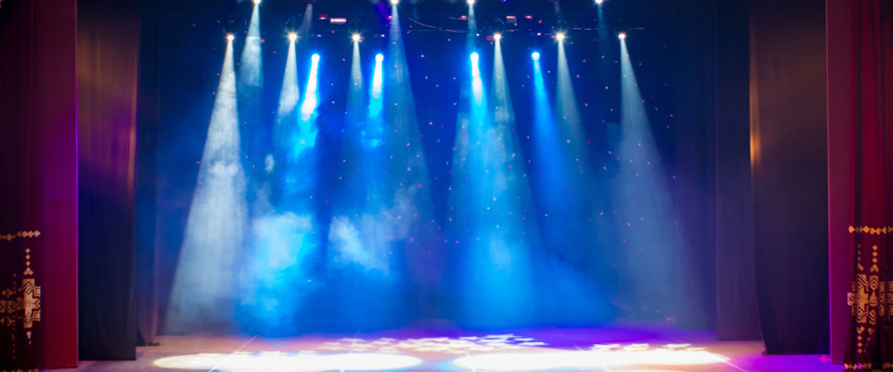 A bare stage with spotlights coming down