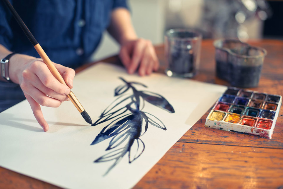 A leafy branch being painted on a blank canvas