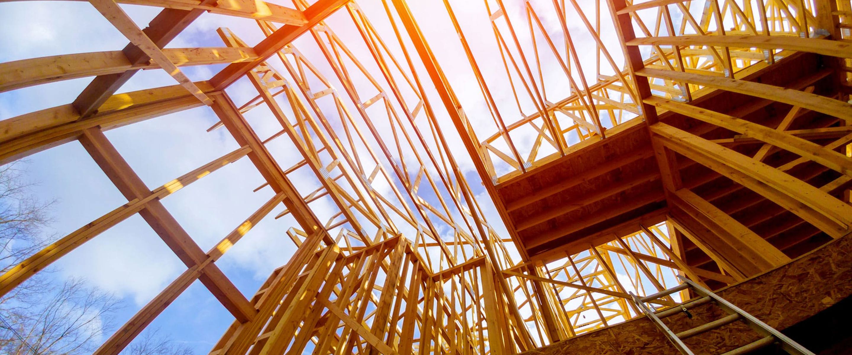 A worm's- eye view of the wooden frame of a house or building 