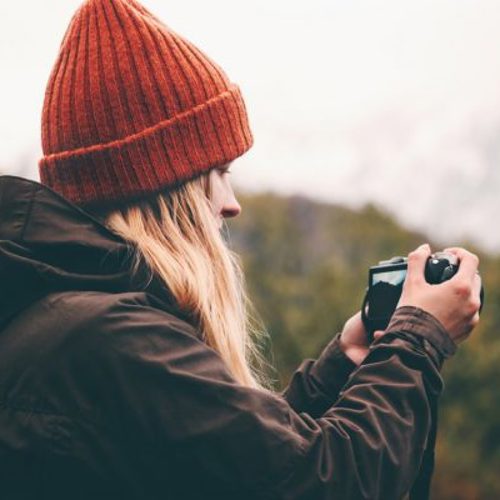 Woman in beanie holding a camera