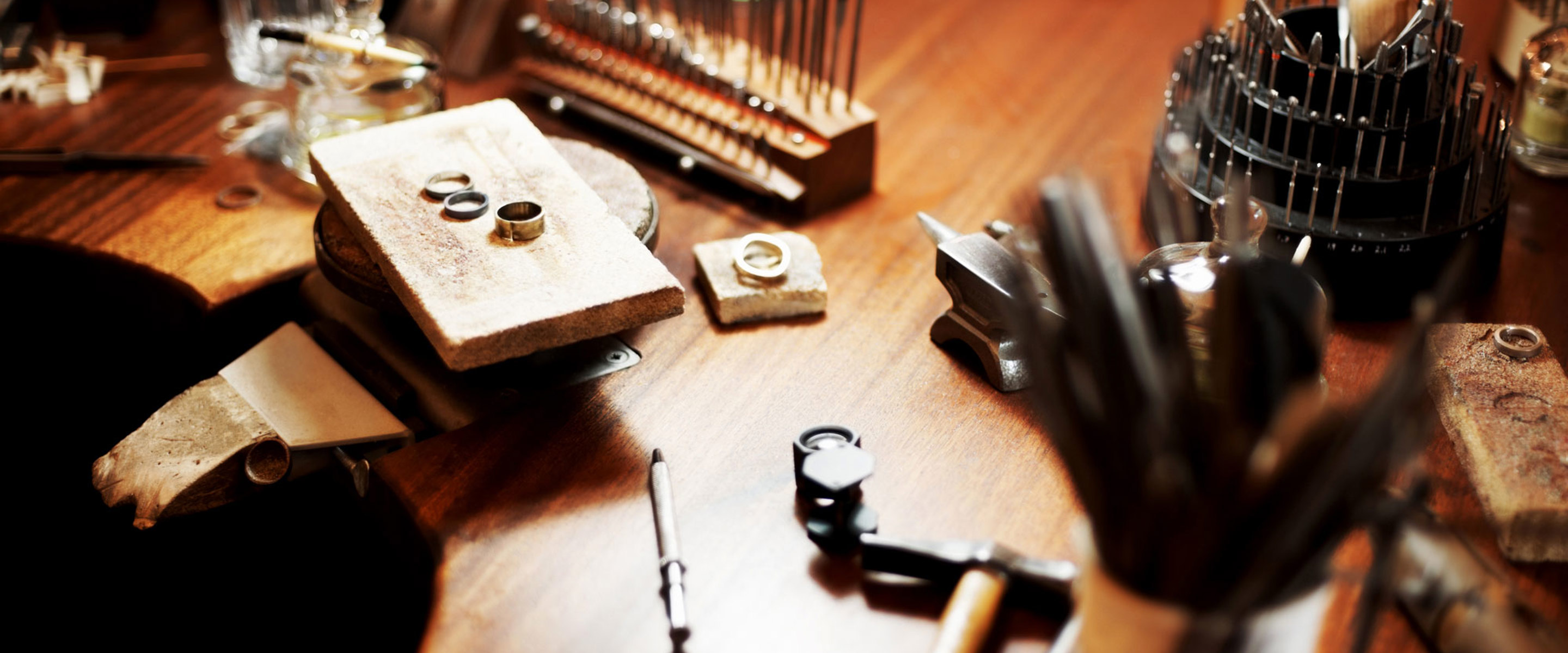 A jewellery work station with rings and tools across it