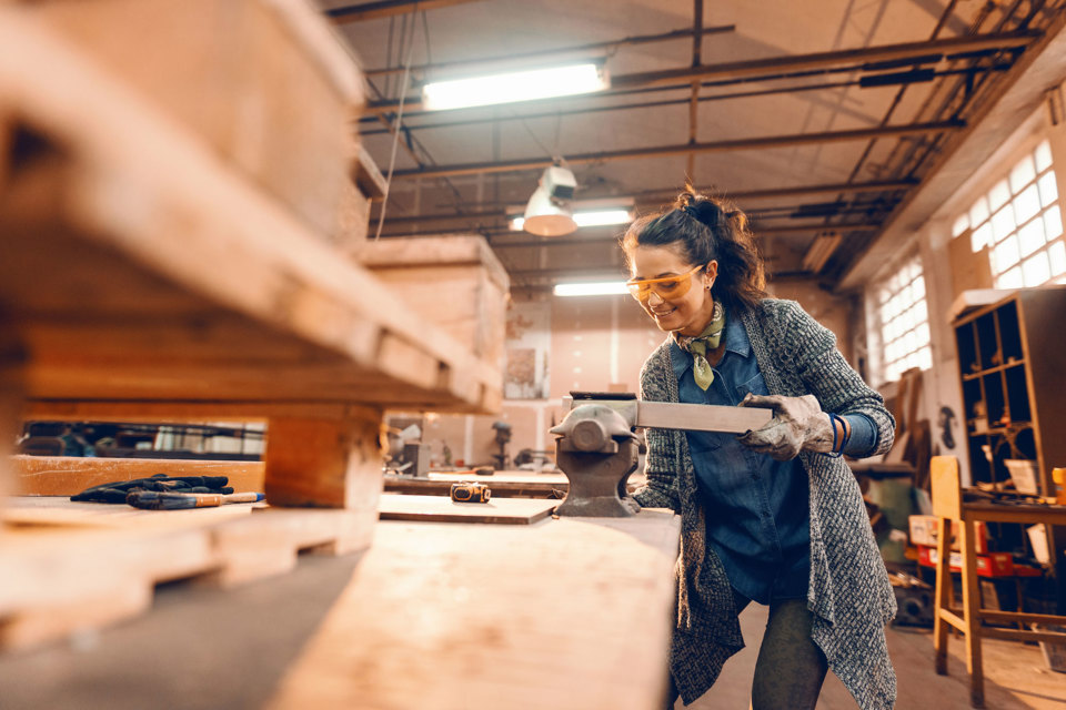 A person cutting wood in a vice