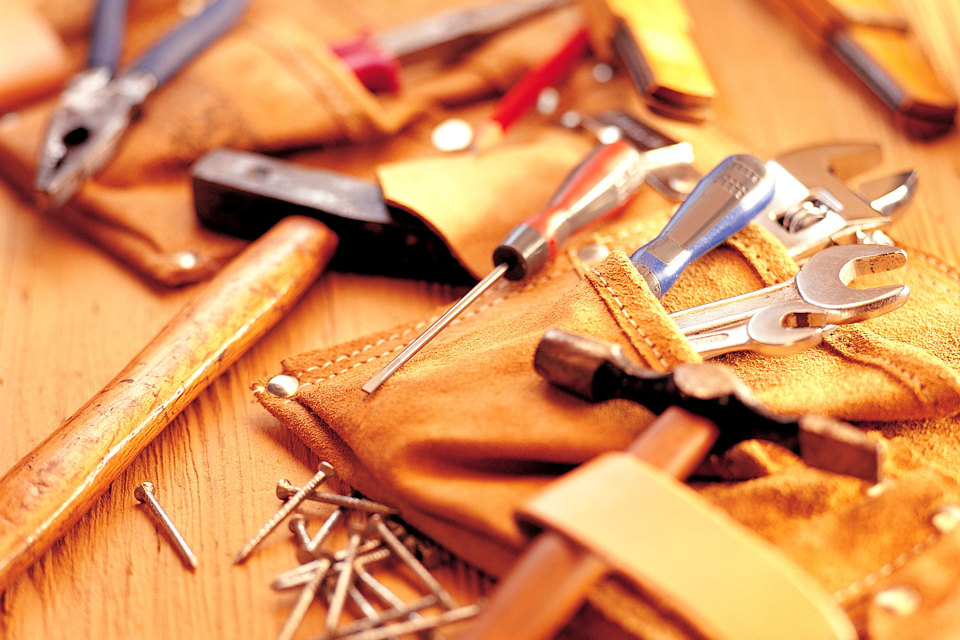 A tool belt full of tools laying across a work station