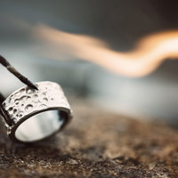 A ring being held by a pair of tweezers