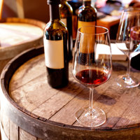 Glasses and bottles of wine sitting on a barrel