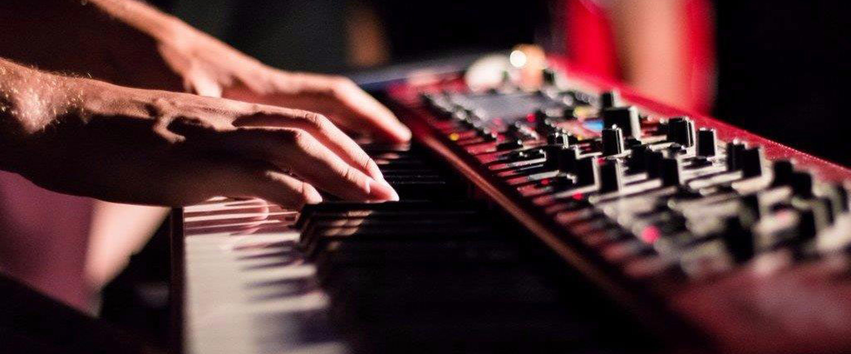 Hands playing a synthesiser 