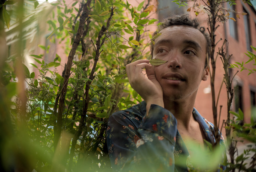 Portrait of man posing within a shrub