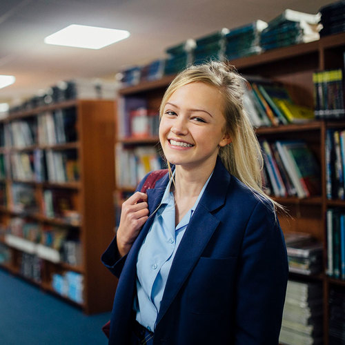 high school student in the library and smiling