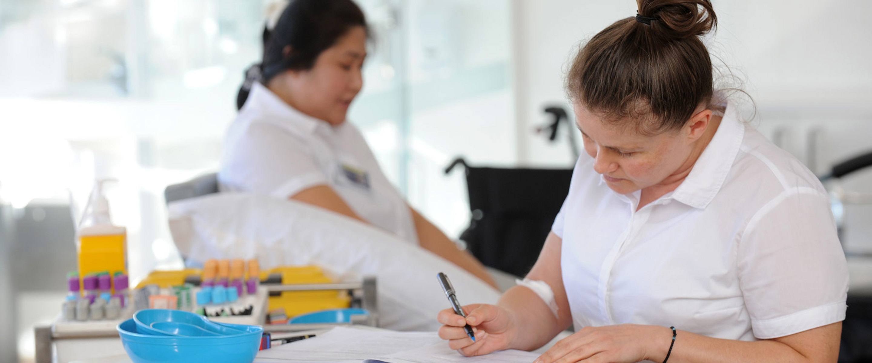 Two students in a pathology lab doing paperwork for samples