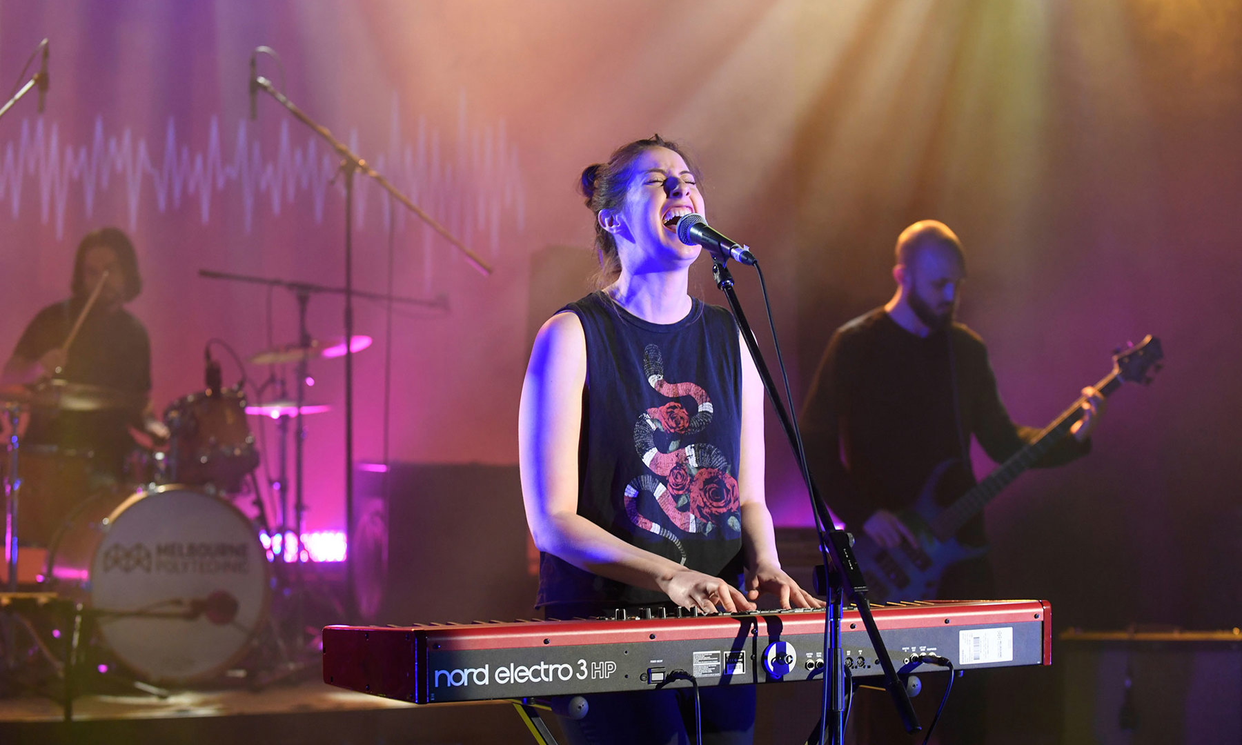 Musician playing a synthesiser and singing with a band