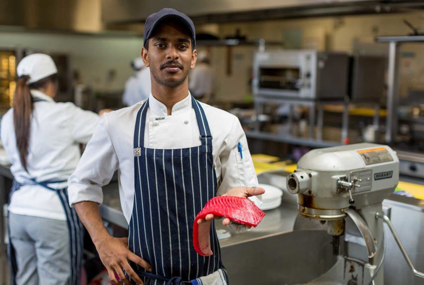 Image of hospitality student holding a fillet of fish