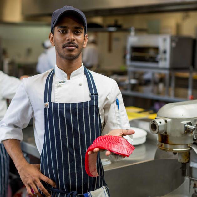 Image of hospitality student holding a fillet of fish