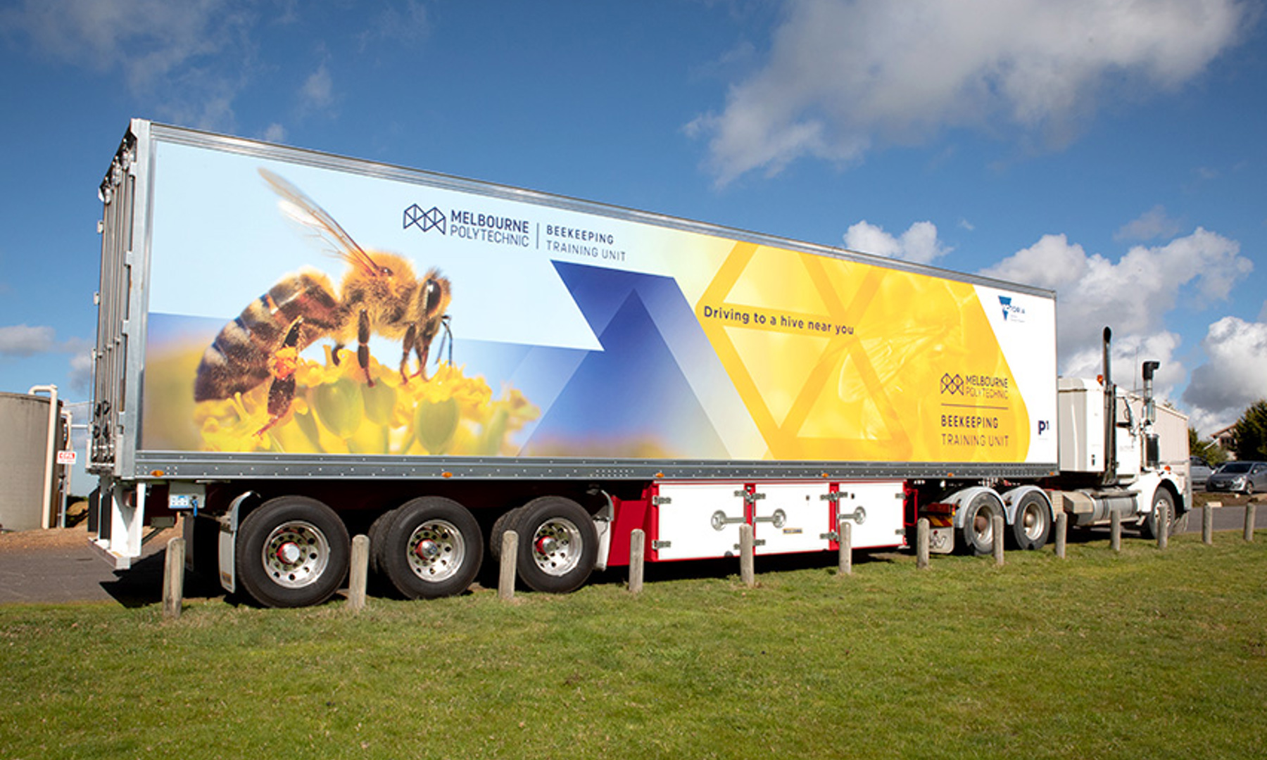 A large truck with "Melbourne Polytechnic Beekeeping Training Unit" and an image of a bee printed on the side.