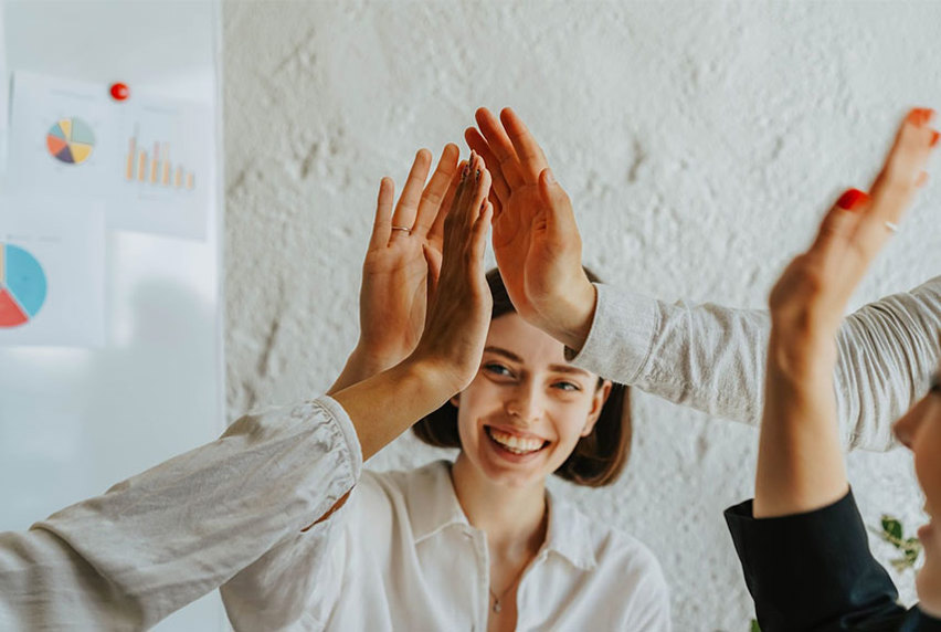 Female student high-fiving fellow students